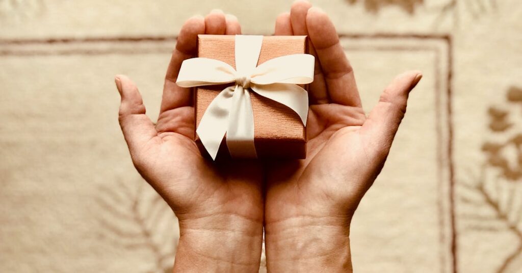 Close-up of hands holding a beautifully wrapped gift box with a ribbon, perfect for celebrations and surprises.